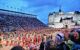 bands marching across the forecourt at dusk in front of the grandstands