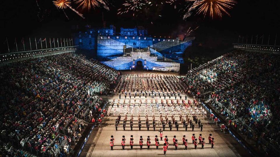 A top overview of the Edinburgh Military Tattoo in performance. Military members stood in a formal structure with a mass amount of audience members on both sides