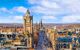 An overview of Old town Edinburgh and Edinburgh castle in Scotland. thousands of buildings covering the ground with on a blue sunny day with a scatter of white clouds