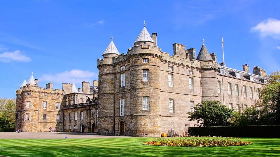 A photo of the Palace of Holyroodhouse, official residence of the Queen in Scotland, a stone building with small pointed turrets