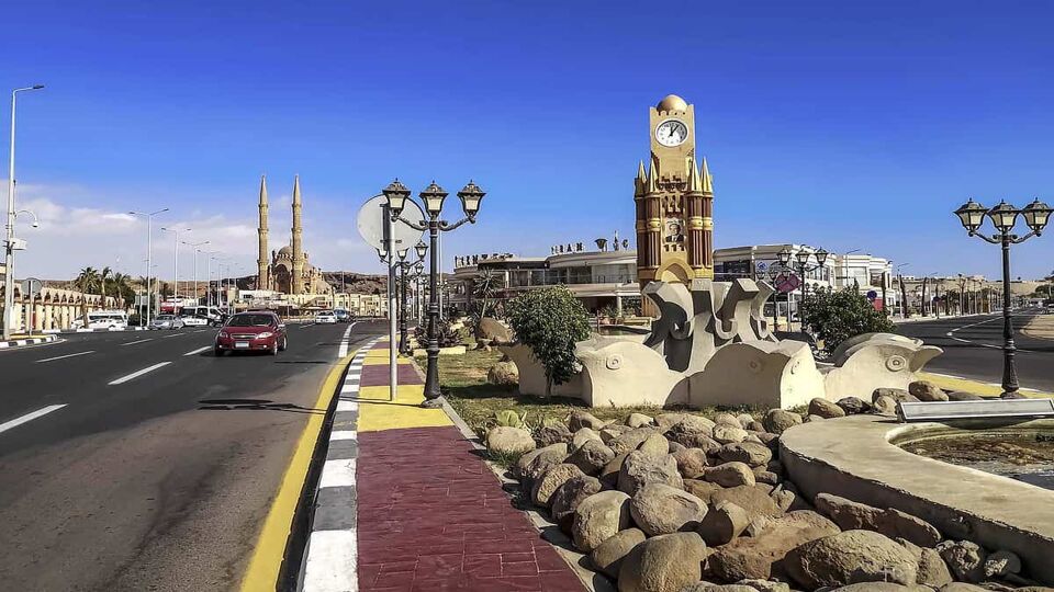 Clock Tower and El Sahaba Mosque in the Old Market in Sharm El Sheikh. City street with car on the road and tourist attractions on a sunny day