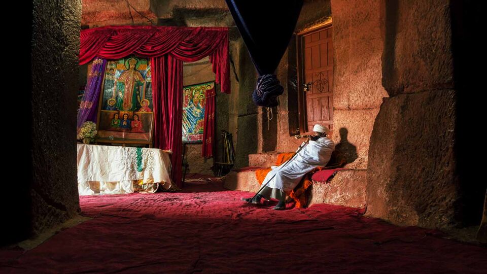 local man sitting inside the Church of St. George, Lalibela