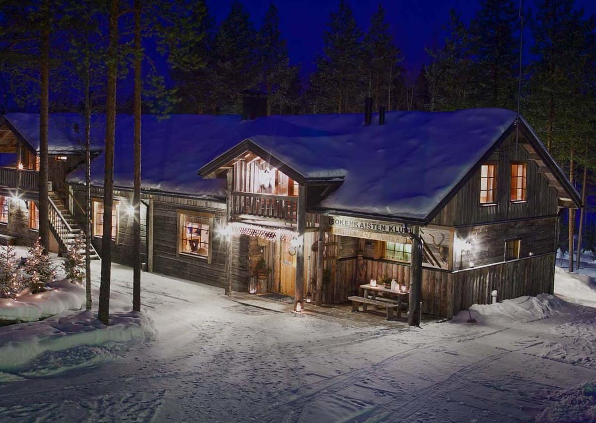 exterior aerial view of the timber main lodge building lit up at night