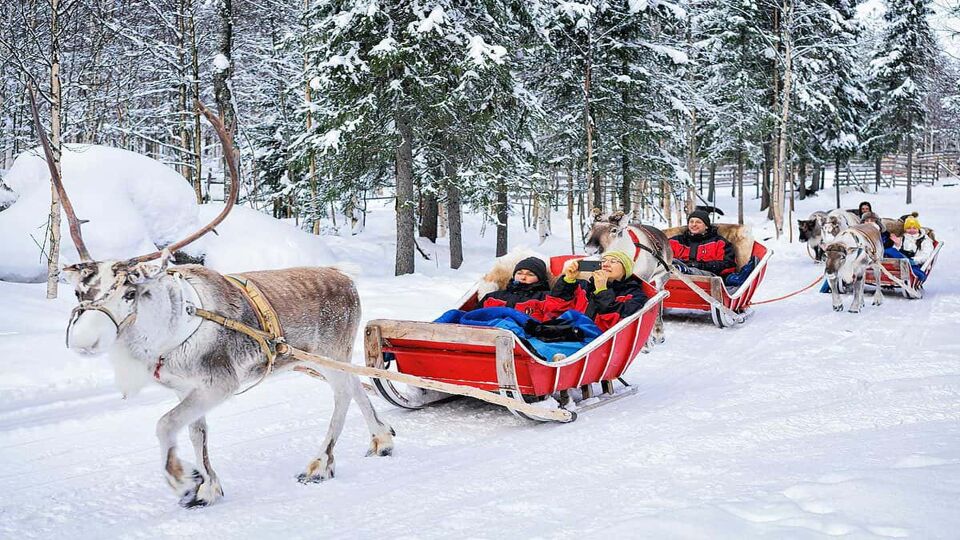 children on a reindeer sleigh ride in Finnish Lapland