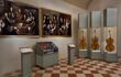 Exhibition room with paintings and a collection of guitars