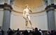 View of the statue on a plinth in the museum, with crowds below