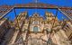 Facade of Cathedral of Santiago de Compostela with blue sky and grille