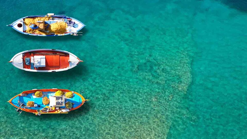Aerial top down photo of traditional wooden fishing boat anchored near picturesque port of Spetses island, Saronic gulf, Greece