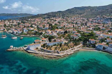 Aerial drone photo of picturesque chapel of Agios Mamas and three cannon monument in picturesque old seaside town of Spetses island, Saronic gulf, Greece