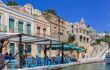 Panoramic view, aerial skyline of small haven of Symi island. Village with Street Cafe and colorful houses located on rock.