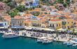 Fishing boats moored in Yialos harbour on August 02, 2014 on Symi island, Greece. Yialos, the main harbour on Symi, is a popular destination for day trips from Rhodes.