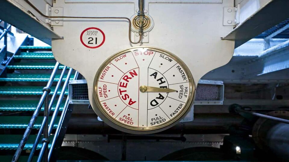 A photo of the engine order telegraph meter attached to a wall to communicate the speed of the ship