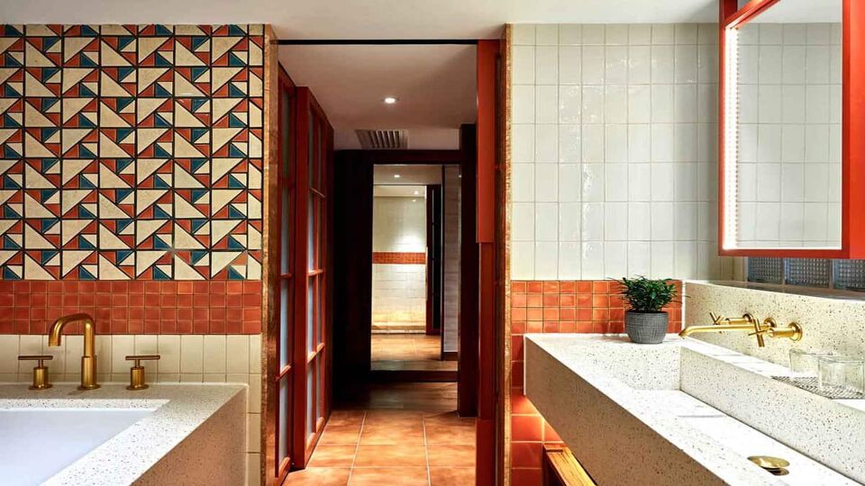 Bright and uniquely tiled bathroom leading to a corridor