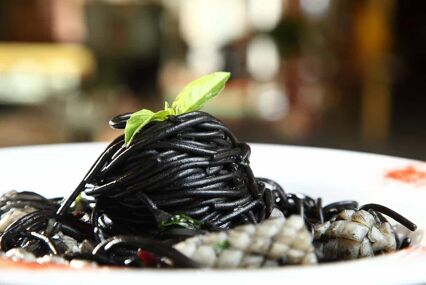 A bowl filled with squid ink pasta