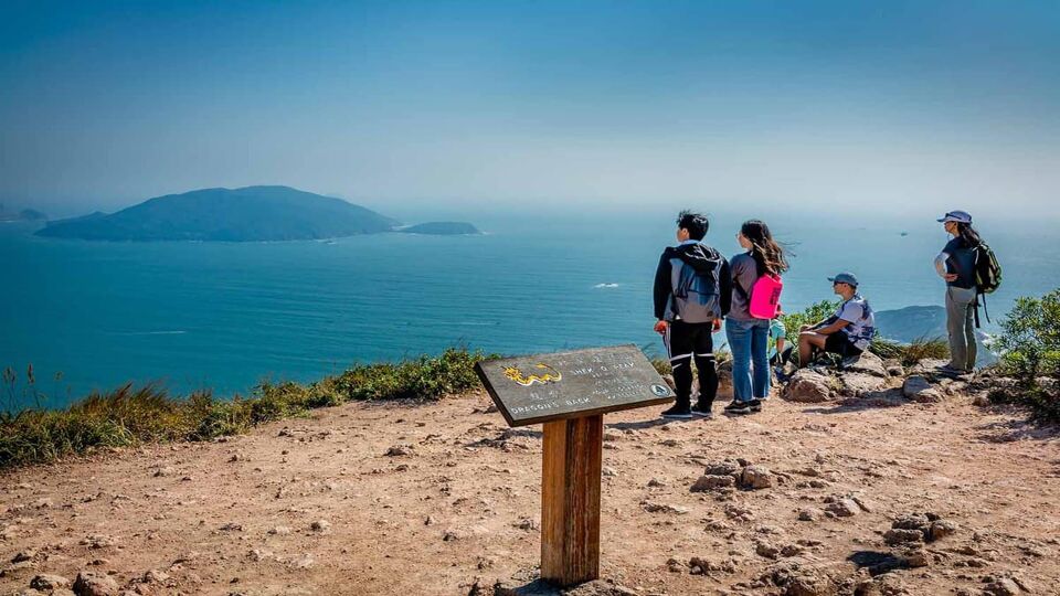 Tourists standing at the Shek O peak - the highest point of the hike