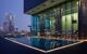 Large outdoor swimming pool adjacent to the hotel gym at dusk