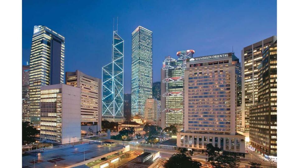 Exterior of the hotel at night, lit up next to other dazzling skyscrapers