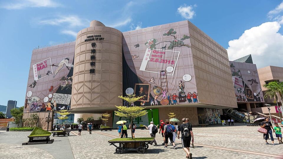 Exterior of the museum with a tree in the foreground and visitors around the building