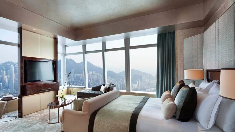 Large double bed and living area with a TV and a view over the peak