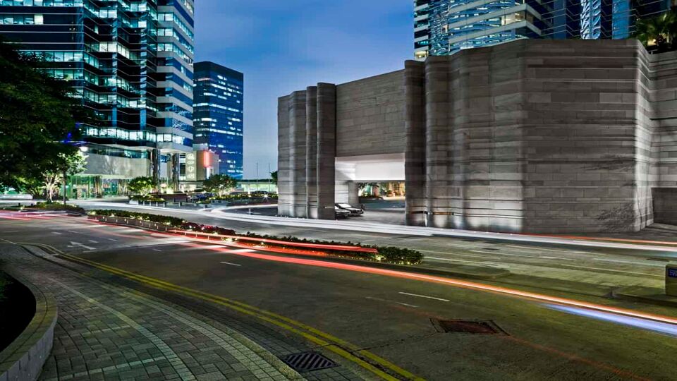 The road in front of the hotel, showing the car park, at dusk