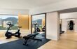 Hotel gym with large windows looking out onto the hillside