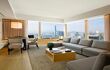 Large L-shaped sofa in living area with windows that look out onto the harbour