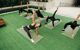 Group of people stretching on yoga mats on the lawn terrace