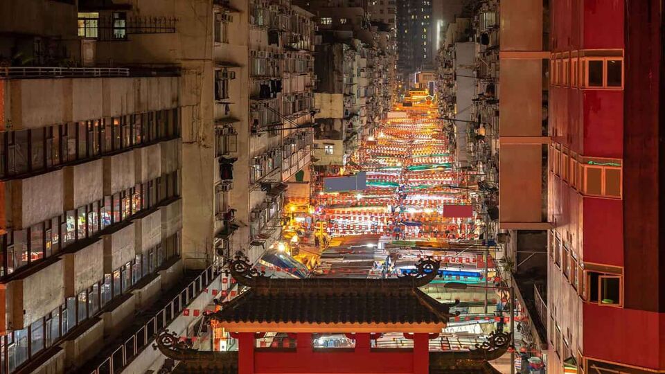 Aerial view of the Temple Street night market, glowing from the neon signs