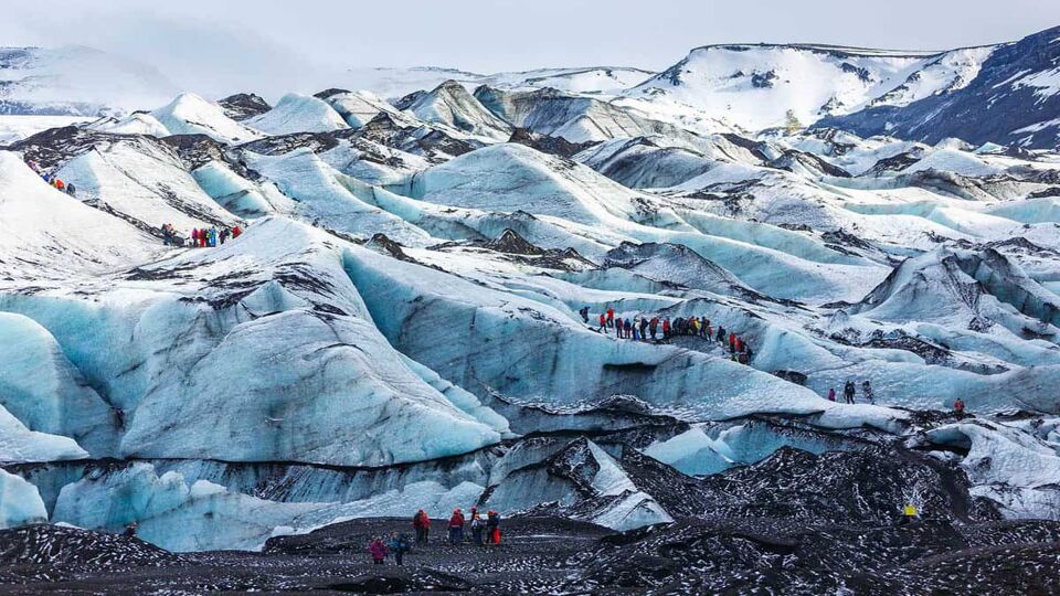 Private guide and group of hiker walking on glacier at Solheimajokull, Iceland