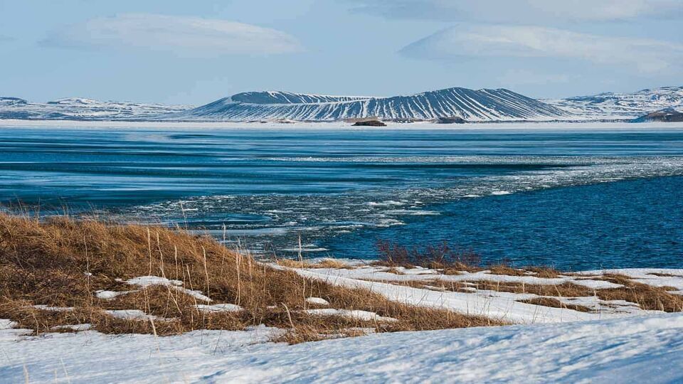 beautiful wintry landscape of Lake Myvatn with volcano cone in centre