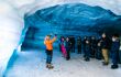 Tour guide showing tour group in a ice cave