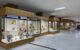 Well-lit interior of museum with glass cabinets housing ancient pottery