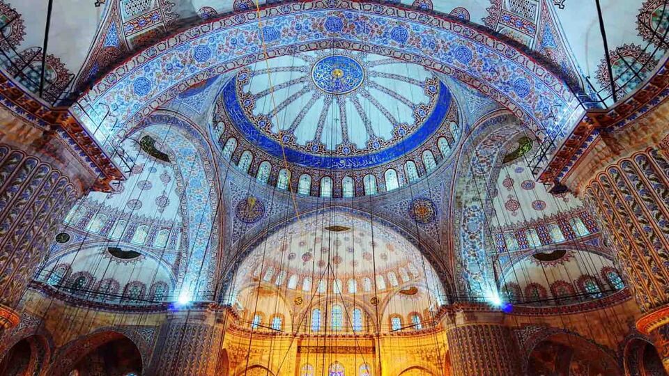 Domed interior of mosque decorated in blue tiles