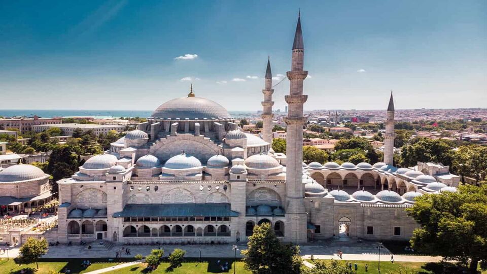 Aerial view of large blue and white mosque on a sunny day