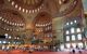 visitors at a grand mosque with red carpeting