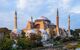 Exterior view of mosque with four minarets at golden hour