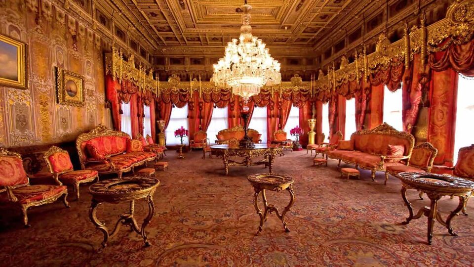 Palace room with plush red sofas and illuminated chandelier
