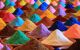 Colourful, triangular piles of spices in round terracotta dishes