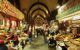 Arched interior of a covered market hall with individual spice shops lining the walls