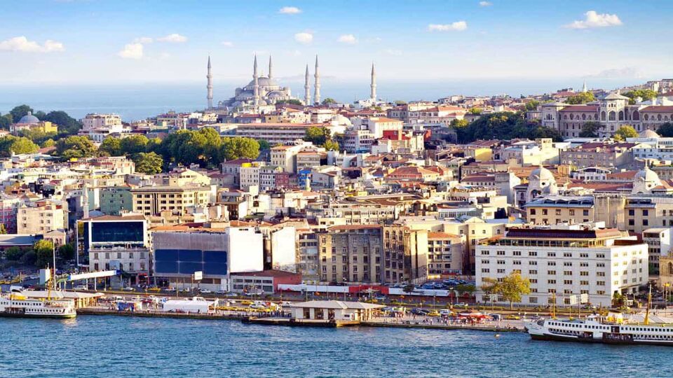 Crowded city of Istanbul with sea in foreground and grand mosque in background