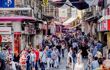 Many citizens and tourists walking on a street in Istanbul full of typical shops