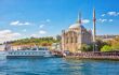 Waterfront mosque on a sunny day with ferry in front