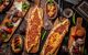 Overhead shot of a table dotted with pide – a canoe-shaped Turkish equivalent of pizza – alongside other platters of meat cutlets and side dishes