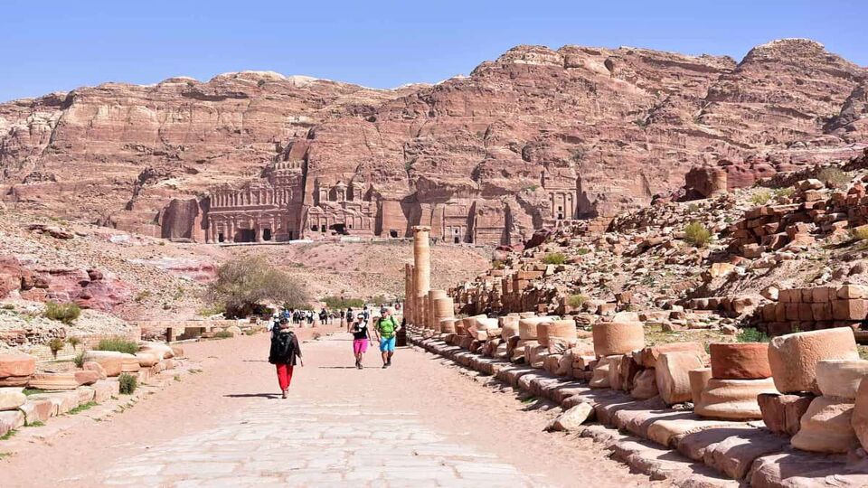 Tourists wandering along footpath in the ruined city of Petra