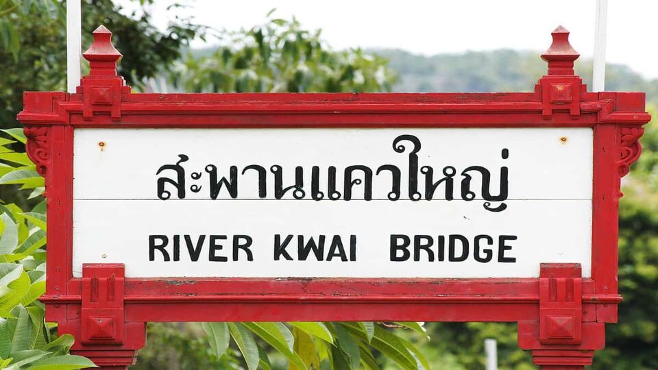 Signpost with "River Kwai Bridge" in English and Thai