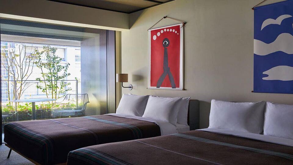 Two double beds in hotel room and Japanese wall art