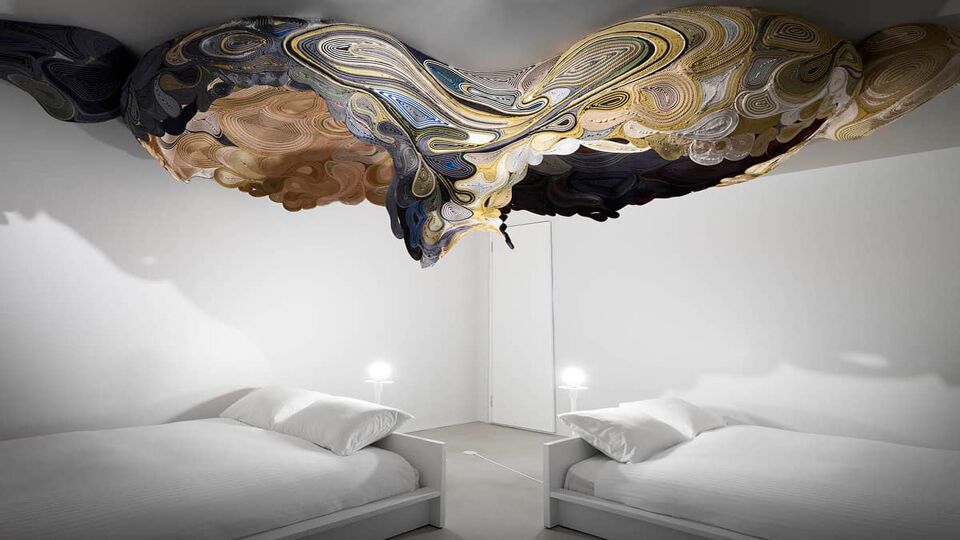 Beds under metal ceiling art installation