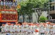 people in white costumes pulling a lrage float