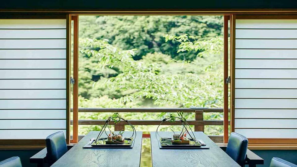 Table laid with two meals by open shoji onto dense nature