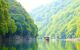 Boat on water in valley with greenery either side